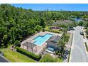 An aerial view showcases the community pool, playground, and surrounding lush landscape at 1918 Marabou Dr, Davenport, FL 33896