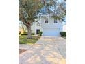 Two-story home with a well-maintained lawn, mature trees, and a light blue and white exterior paint scheme at 2131 Nicollett Way, Leesburg, FL 34748