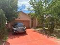 Traditional style home with well maintained landscaping and a red driveway at 220 Abbotsbury Dr, Kissimmee, FL 34758