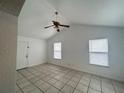 Inviting bedroom with neutral walls, tile flooring, and a ceiling fan at 2322 Vincent Rd, Orlando, FL 32817