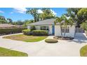 Charming single-story home with a well-manicured lawn, lush green bushes, and a blue front door at 2812 E Michigan St, Orlando, FL 32806