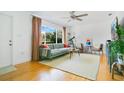 Bright living room with hardwood floors, large window with backyard views, and comfortable modern furnishings at 2812 E Michigan St, Orlando, FL 32806