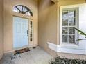 Close up of the front door with decorative trim and a window beside it at 2850 Tremont Dr, Eustis, FL 32726