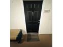 This is a home entrance with a black door with the house number 20112 with a bench on the side at 315 Grand Magnolia Ave # 112, Celebration, FL 34747