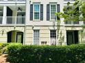 An exterior angle view of a building with balconies, windows with black shutters, and a hedge row in front at 315 Grand Magnolia Ave # 112, Celebration, FL 34747