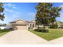 Well maintained home with a spacious driveway and beautiful mature landscaping in a suburban neighborhood at 36300 Grand Island Oaks Cir, Grand Island, FL 32735