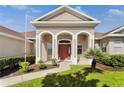 Inviting home exterior featuring arched entryway, well-kept landscaping, and a charming palm tree at 36300 Grand Island Oaks Cir, Grand Island, FL 32735