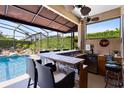 Outdoor kitchen by the pool featuring bar seating, counter space, and beverage refrigeration at 421 Thomez Ct, Lake Mary, FL 32746