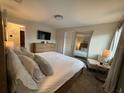 Bright main bedroom features a comfortable king-size bed and a modern dresser with a wall-mounted TV at 4800 Lullaby Ln, Kissimmee, FL 34746