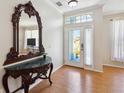 Elegant foyer featuring a beautiful mirror, decorative table, and light-colored flooring at 5815 Pine Grove Run, Oviedo, FL 32765