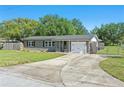 Single-story home with an attached garage, a well-kept lawn, and a concrete driveway and fenced yard at 62 Magnolia Dr, Debary, FL 32713