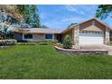 Charming single-Gathering home featuring a well-manicured front yard and attached 2-car garage at 7845 Clubhouse Estates Dr, Orlando, FL 32819
