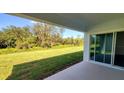 Covered patio with sliding glass doors overlooking a large backyard and wooded area at 1032 Morfontaine St, Daytona Beach, FL 32124