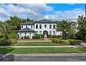 Beautiful two-story home with lush landscaping, mature palm trees, and a welcoming walkway at 10849 Emerald Chase Dr, Orlando, FL 32836