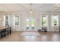 Bright and spacious living room featuring wood floors, large windows, and stylish french doors at 1103 Lindley Cove Cir, Deland, FL 32724