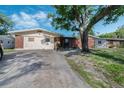 Single story home with a concrete driveway and brick and light stucco exterior at 1136 Lakewood Park Dr, Daytona Beach, FL 32117