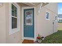 Stylish front door with decorative glass, complemented by a welcoming mat and potted plants at 1168 Lakeshore Breeze Pl, Kissimmee, FL 34747