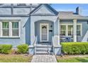 Close up of charming light blue bungalow with a brick pathway leading to the front door at 1413 W Harvard St, Orlando, FL 32804