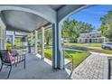 View from the covered front porch with stone floors and an archway, complete with chairs at 1413 W Harvard St, Orlando, FL 32804