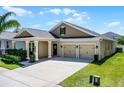 Inviting single-Gathering home with a covered porch and a two-car garage, surrounded by green grass at 15186 Book Club Rd, Winter Garden, FL 34787