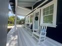 Spacious front porch furnished with white rocking chairs and a charming light blue front door at 1521 E Harwood St, Orlando, FL 32803