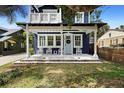 Inviting front porch with white rocking chairs, decorative tile, and a charming light blue front door at 1521 E Harwood St, Orlando, FL 32803