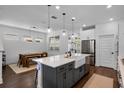 Bright kitchen with a large island, stainless steel appliances, and open layout to the dining area at 15408 Lebeau Loop, Winter Garden, FL 34787