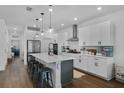 Spacious kitchen features a large island with seating, modern stainless steel appliances, and sleek white cabinets at 15408 Lebeau Loop, Winter Garden, FL 34787