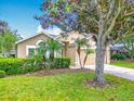 Lovely one-story home with a manicured lawn, mature trees, and a two-car garage on a sunny day at 1961 Lochshyre Loop, Ocoee, FL 34761