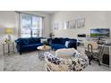 Comfortable living room with bright window and a pair of blue sofas for the perfect gathering space at 2712 Lido Key Dr, Kissimmee, FL 34747