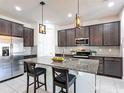 Kitchen island featuring granite countertops, pendant lighting, and dark wood cabinetry at 308 Buchannan Dr, Davenport, FL 33837