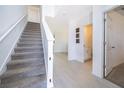 Bright entryway with staircase and tile flooring, leading to a half-bathroom and living spaces at 3134 Viceroy Ct, Poinciana, FL 34759