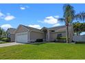 Lovely single-story home with a two-car garage, lush green lawn, and mature palm tree enhancing curb appeal at 3220 Harpers Ferry Ct, Orlando, FL 32837