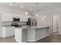 Modern kitchen with stainless steel appliances, white cabinets, and a central island with granite countertops at 4026 Ruby Run, Haines City, FL 33844