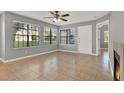 Bright living room with tiled floors, ceiling fan, and large windows offering abundant natural light at 420 Forestway Cir # 108, Altamonte Springs, FL 32701
