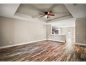Open-concept living area featuring wood flooring and a tray ceiling with a ceiling fan at 510 Fahnstock St, Eustis, FL 32726