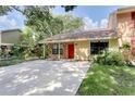 Charming home featuring stone accents, a bright red front door, and well-maintained lawn at 5518 Cretan Way, Winter Park, FL 32792
