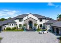 Luxurious home with stone accents, a paved driveway, professional landscaping, and a car parked in the front at 570 Manor Rd, Maitland, FL 32751
