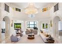 Stunning living room featuring a grand chandelier, elegant furnishings, and views of the water at 570 Manor Rd, Maitland, FL 32751