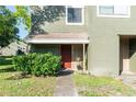 Close-up of front entrance with a red door and well-maintained landscaping at 5961 Windhover Dr # F05, Orlando, FL 32819