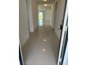 Bright hallway with glossy tile flooring leading to a living area with sliding glass doors at 604 Sarner Pass Way, Winter Haven, FL 33881
