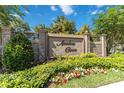 Stone community sign for Azalea Cove surrounded by lush landscaping and colorful flower beds at 7545 Azalea Cove Cir, Orlando, FL 32807