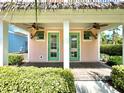 Cozy peach colored house featuring double doors, fans and shutters at 8001 Sand Bar Dr, Kissimmee, FL 34747