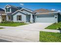 Street view of a blue single-story home with a well-manicured lawn and two-car garage at 917 Jackson Ave, Davenport, FL 33837