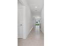 Bright, neutral hallway featuring tile flooring and access to various rooms at 917 Jackson Ave, Davenport, FL 33837