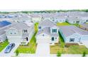 Aerial view of a new residential neighborhood with similar two-story homes, green lawns, and ample parking at 921 Jackson Ave, Davenport, FL 33837