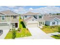 Aerial view of a well-maintained two-story home with green lawn, spacious driveway, and a neatly landscaped yard at 921 Jackson Ave, Davenport, FL 33837