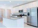 Bright, modern kitchen with stainless steel appliances, a central island, and ample white cabinet space at 921 Jackson Ave, Davenport, FL 33837