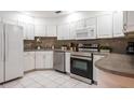 Bright kitchen featuring white cabinets, stainless steel appliances, and tiled backsplash at 935 Amy Ridge Ct, Kissimmee, FL 34747