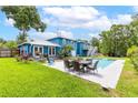 A beautiful blue house featuring a refreshing backyard pool and outdoor dining area at 1046 Blackwood St, Altamonte Springs, FL 32701